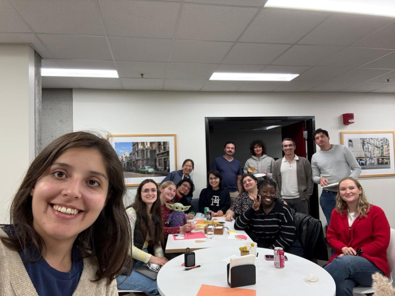 A group of FHIS graduate students gathered around tables for a Friendsgiving event.